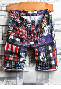 Detailed view of men's loose denim shorts featuring multi-color patchwork plaid patterns