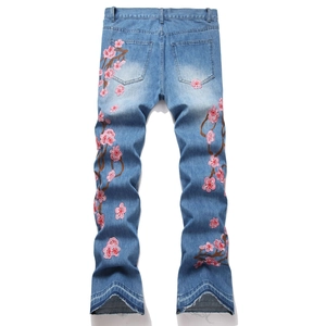 Jean flare homme bleu clair avec broderie cerisier rose et détails effilochés au bas