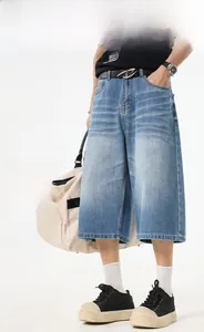 Detail of light blue washed denim cropped pants with a relaxed wide-leg straight fit