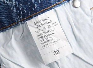 Macro detail of the product wash label showing 97% cotton and 3% elastane fabric content