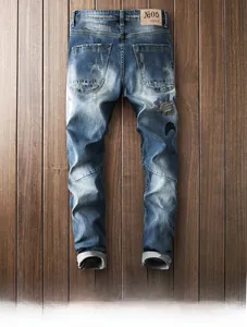 Detail of distressed blue jeans with moon star embroidery and retro leather brand patch
