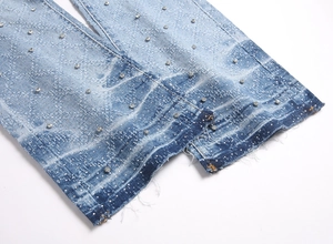 Detail of light blue flared denim hem with rhinestones, distressed wash and frayed edges