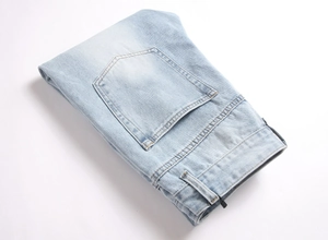 Detailed view of stitching and texture on the back pocket of light blue denim jeans