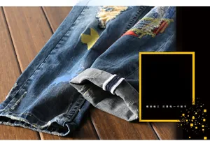 Detailed close-up of distressed denim with star embroidery and frayed hem detail