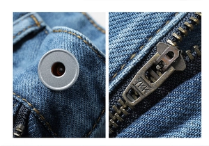 Detail view of the high-quality YKK metal zipper and button on washed blue denim shorts