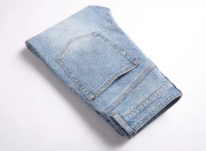Close-up of light blue flared jeans with sparkling rhinestones and acid wash denim texture