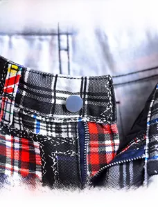 Close-up of tartan plaid fabric waist with durable button and metal zipper detail