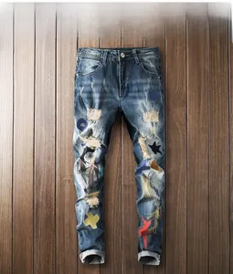 Detail view of heavy distressed blue jeans with colorful star and moon patchwork