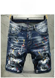 Detailed close-up of distressed denim shorts featuring hand-painted splatters and patches