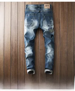 Close-up of distressed back pocket and moon star embroidery on blue men's denim jeans