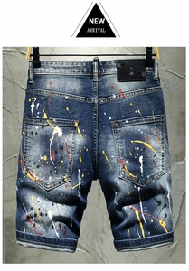 Detail of distressed dark blue denim shorts with paint splatters and leather waist patch