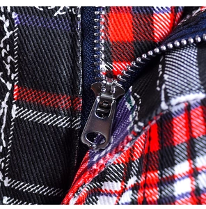 Detailed close-up of high-quality metal zipper and multicolor plaid fabric texture