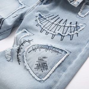 Men's punk streetwear light blue flare jeans with distressed rips and black embroidery