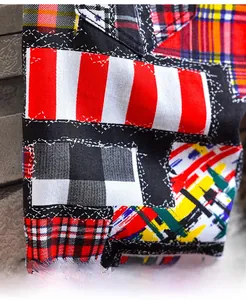 Detail of trendy patchwork plaid denim shorts featuring various tartan fabric patterns