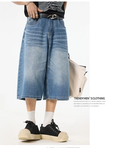 Detail of light blue washed denim wide-leg shorts with cat whisker texture design