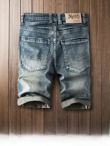 Détail du short en jean bleu vintage montrant l'étiquette en cuir et la broderie