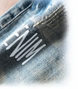 Gros plan sur le denim bleu délavé avec texture vintage et imprimé de lettres Denim