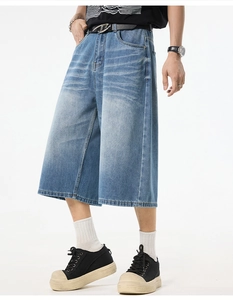Detail of light blue washed denim capris featuring a wide-leg cut and black belt
