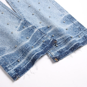 Men's light blue flare jeans with decorative silver rhinestones and raw hem detail