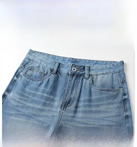 Detail of light blue denim waist with metal button and vintage washed whiskering effect