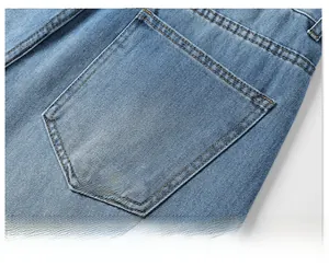 Close-up of back pocket details on washed blue loose-fit straight-leg denim shorts