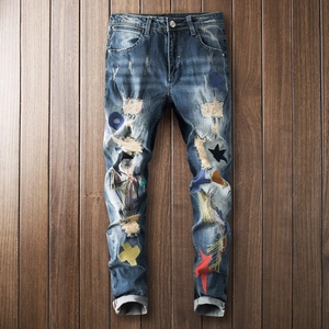 Distressed slim fit denim jeans with colorful patchwork and ripped star embroidery details