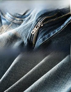 Détail des poches effilochées et de la fermeture éclair sur short en jean bleu