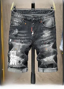 Dettaglio dei pantaloncini in denim con schizzi di vernice colorata e toppe decorative