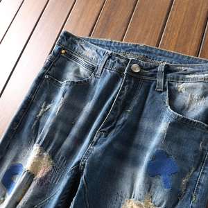 Distressed blue denim jeans for men with moon and star embroidery and ripped details