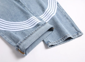 Détail de l'ourlet en denim bleu clair avec triple bandes blanches et coutures jaunes