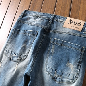 Vintage distressed denim jeans with celestial embroidery and a leather patch detail