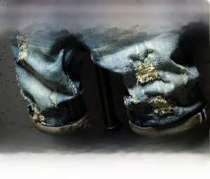 Macro detail of lightning distressed denim and reinforced double stitching on men's shorts