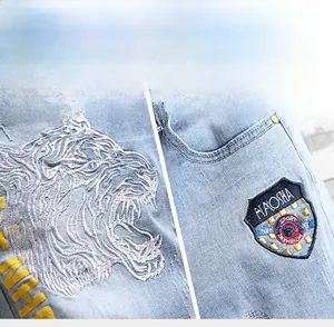 Détail de la broderie tête de tigre et de l'écusson sur le short en jean bleu clair