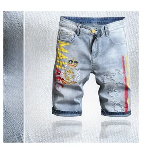 Détail du short en jean bleu clair avec broderie couronne et imprimé lettrage MAHALO