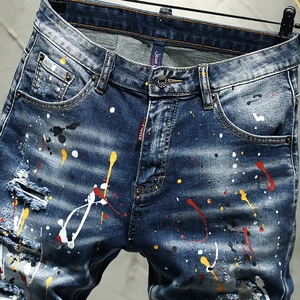 Men's dark blue denim shorts with colorful paint splatter and distressed patchwork style