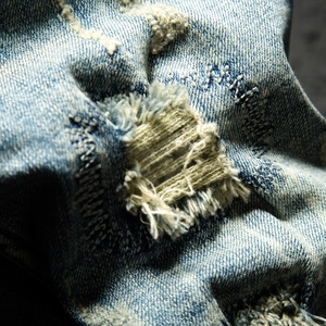 Men's retro loose distressed denim shorts with heavy ripped details and vintage wash
