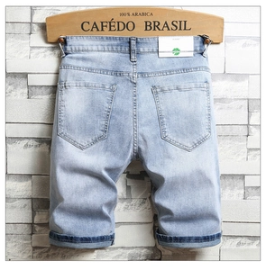 Détail du short en jean bleu clair avec écusson en cuir au dos et ourlet replié stylé