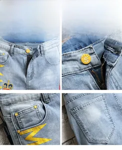 Détails de la broderie couronne et du bouton en métal sur un short en jean bleu