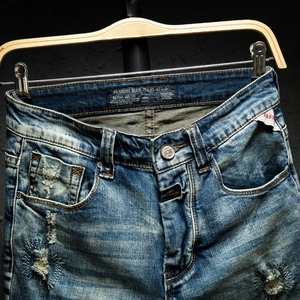 Men's retro loose distressed denim shorts in light blue with vintage wash effects