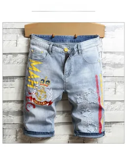 Détail du short en jean bleu clair avec broderie MAHALO et finitions denim déchirées