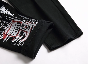 Détail du jean noir slim avec imprimé graffiti abstrait sur le bas de la jambe