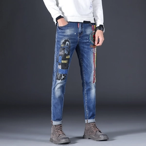Close-up of Bob Marley portrait print and lyrics on slim fit blue washed denim jeans