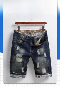 Detail showing vintage printed fabric lining on the distressed denim shorts hem and waist