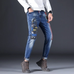Detail of slim fit denim jeans featuring Bob Marley portrait and reggae style print