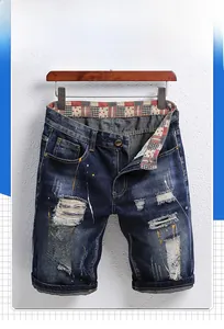 Detail von Destroyed-Denim-Shorts mit handgemalten Farbspritzern und ausgefransten Rissen