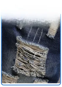 Detail of distressed denim shorts featuring vintage wash effects and ripped hole textures