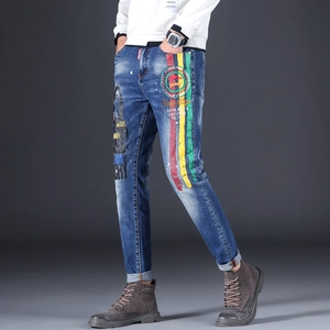 Detail of blue jeans featuring colorful vertical stripes and stylized portrait print