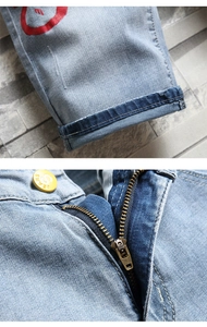Détail de la fermeture éclair YKK et de l'ourlet sur un short en jean bleu clair