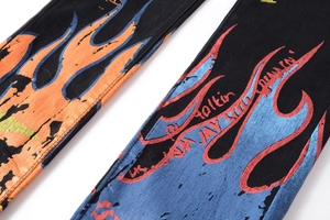 Detail of black slim jeans featuring vibrant orange and blue flame graffiti prints