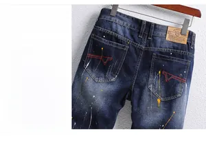 Detailaufnahme von Denim-Shorts mit Farbspritzern und roter geometrischer Stickerei